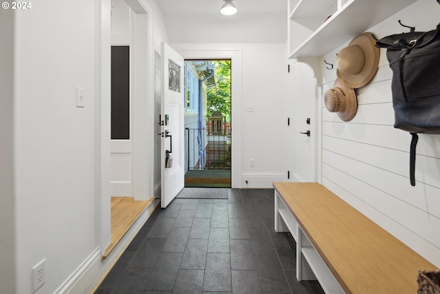 mudroom with dark tile patterned floors