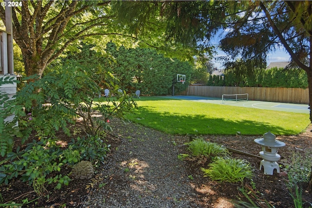 view of yard featuring basketball hoop