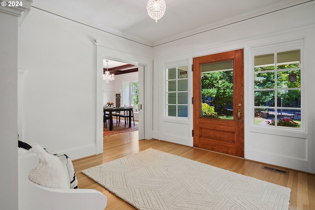 doorway featuring a chandelier and light hardwood / wood-style flooring