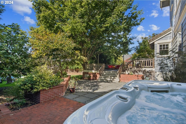 view of patio / terrace with a hot tub and a deck