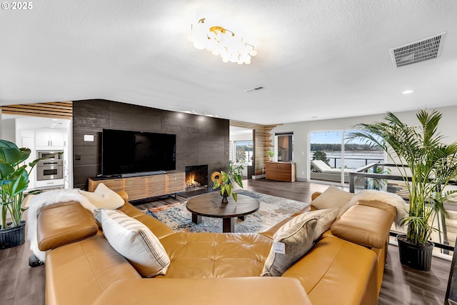 living room featuring hardwood / wood-style floors, a fireplace, and a textured ceiling