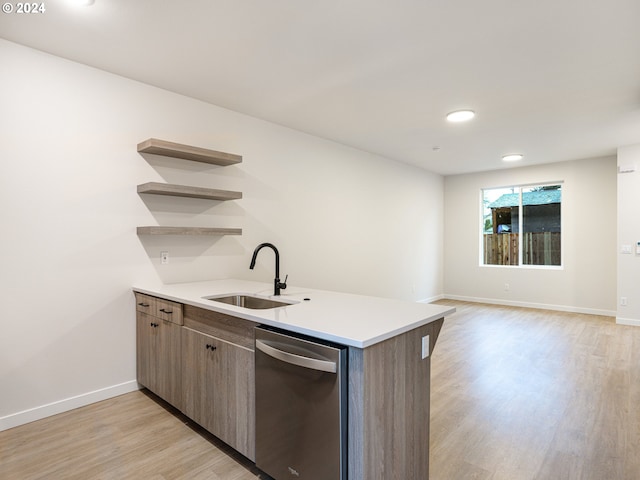 kitchen with stainless steel dishwasher, kitchen peninsula, sink, and light hardwood / wood-style flooring