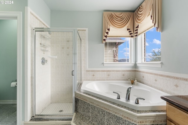 bathroom featuring vanity and independent shower and bath