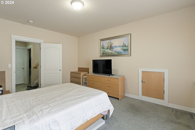 bedroom featuring light carpet and a textured ceiling