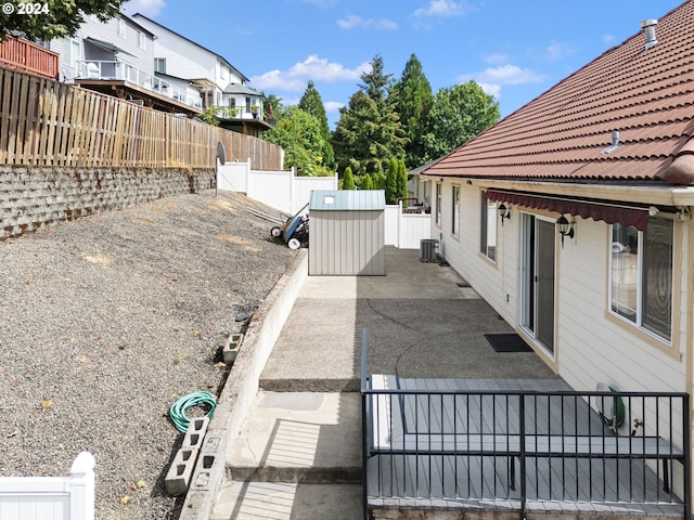 view of side of property with central air condition unit and a patio