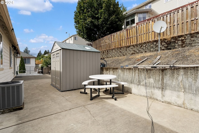 view of patio with central AC unit and a storage shed