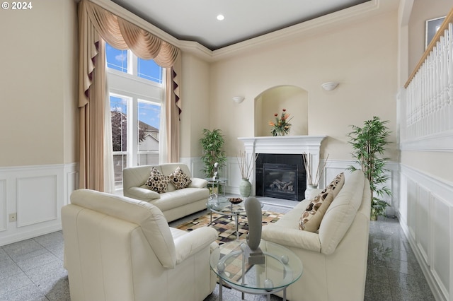 living room with a towering ceiling and ornamental molding