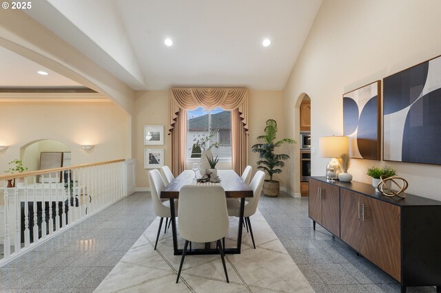 dining space featuring high vaulted ceiling