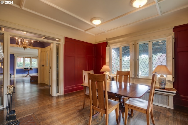 1709 NW Aspen Ave, Portland, OR 97210 - dining space featuring coffered ceiling, crown molding, a notable chandelier, a decorative wall, and dark wood-type flooring