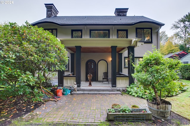 1709 NW Aspen Ave, Portland, OR 97210 - property entrance featuring covered porch, a chimney, and stucco siding