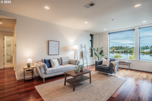 living room featuring hardwood / wood-style flooring and a water view