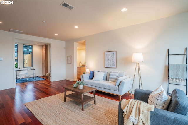 living area with recessed lighting, dark wood-type flooring, visible vents, and baseboards