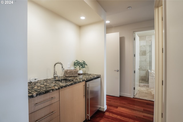 bar featuring dishwashing machine, dark wood-type flooring, wet bar, recessed lighting, and a sink