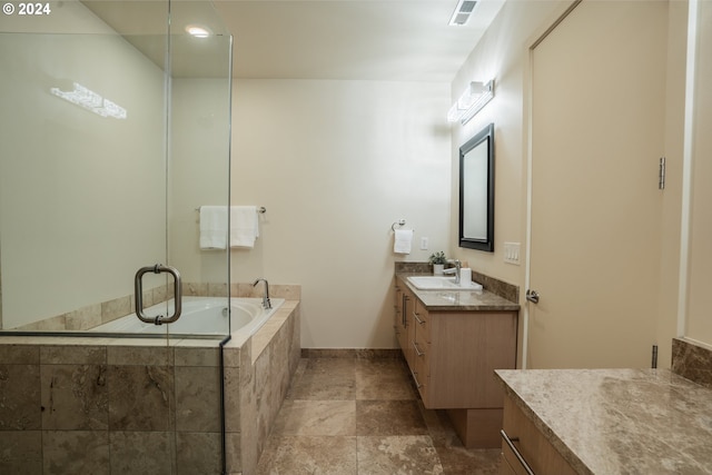 bathroom featuring vanity and independent shower and bath