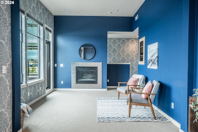 living area with carpet floors and a tiled fireplace