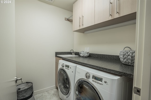 laundry room with washing machine and dryer, sink, light tile patterned flooring, and cabinets