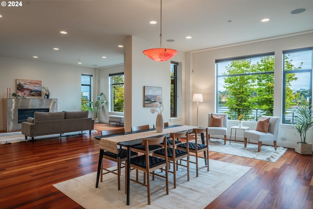 dining space featuring baseboards, recessed lighting, a tile fireplace, and wood finished floors
