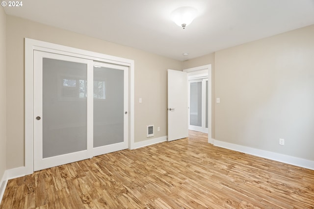 unfurnished bedroom featuring light hardwood / wood-style floors and a closet