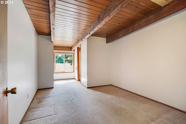 spare room with wood ceiling, beam ceiling, and light colored carpet