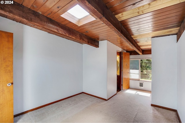 additional living space featuring light carpet, a skylight, beam ceiling, and wooden ceiling