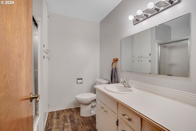 bathroom featuring walk in shower, vanity, toilet, and hardwood / wood-style flooring