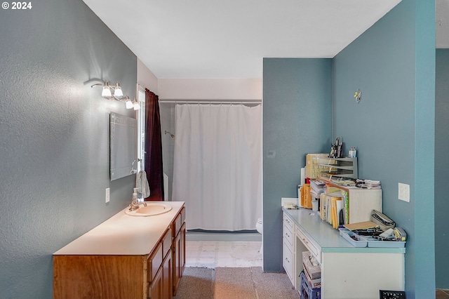 bathroom featuring curtained shower, vanity, and toilet