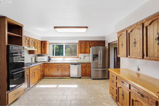 kitchen with stainless steel appliances, tasteful backsplash, and sink