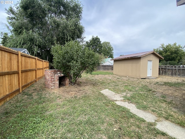 view of yard featuring an outbuilding, a storage unit, and a fenced backyard