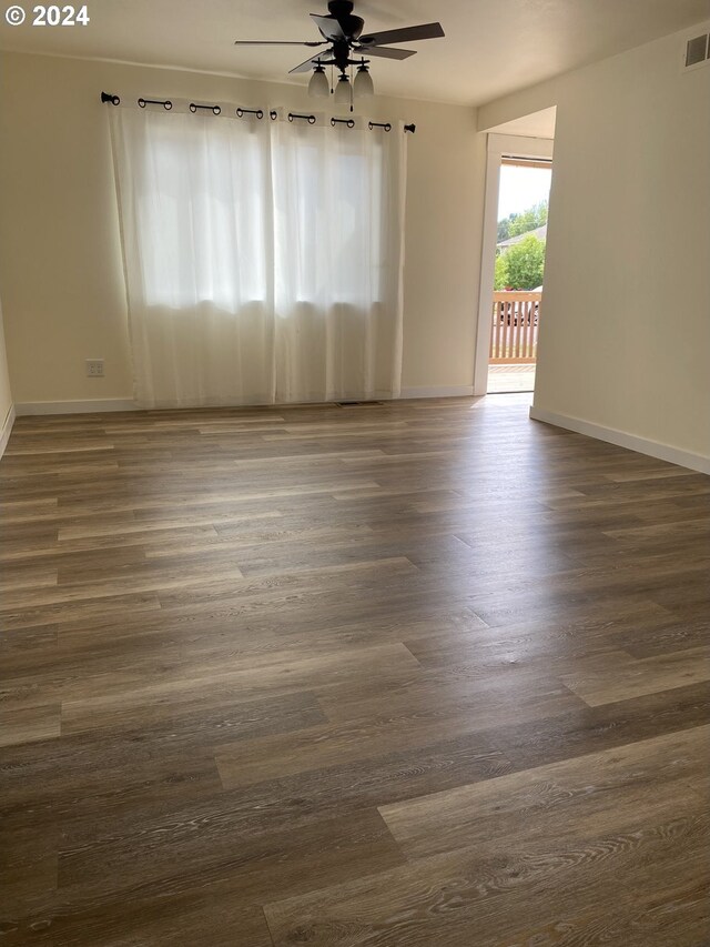 empty room with ceiling fan and dark wood-type flooring