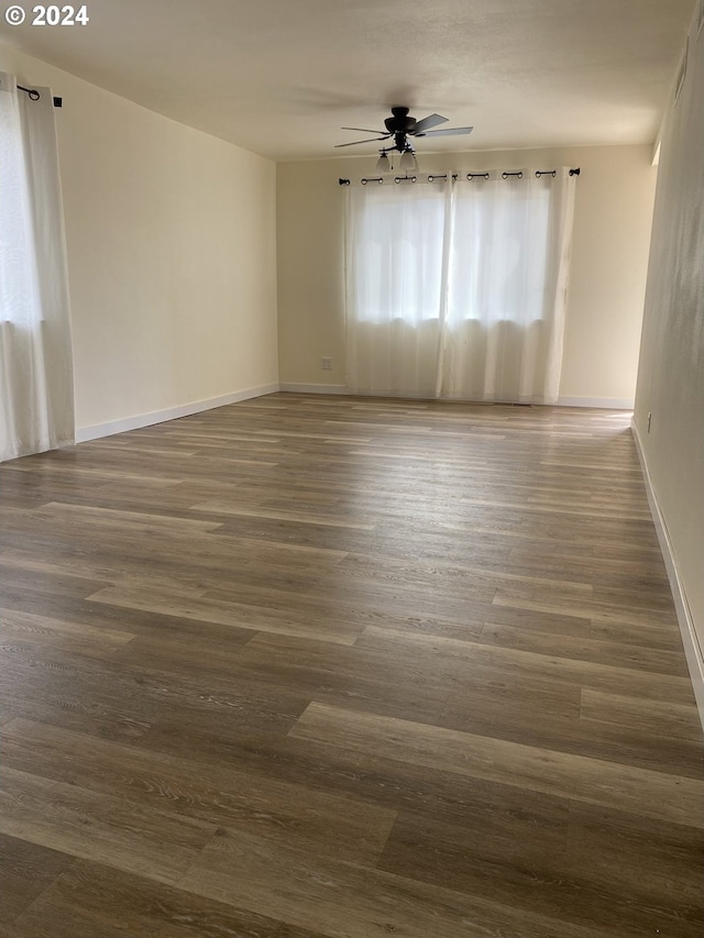 empty room featuring ceiling fan and dark wood-type flooring