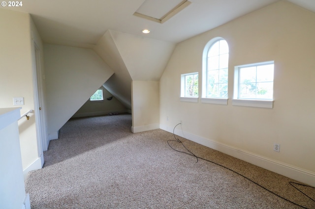 bonus room with light carpet, a wealth of natural light, and vaulted ceiling