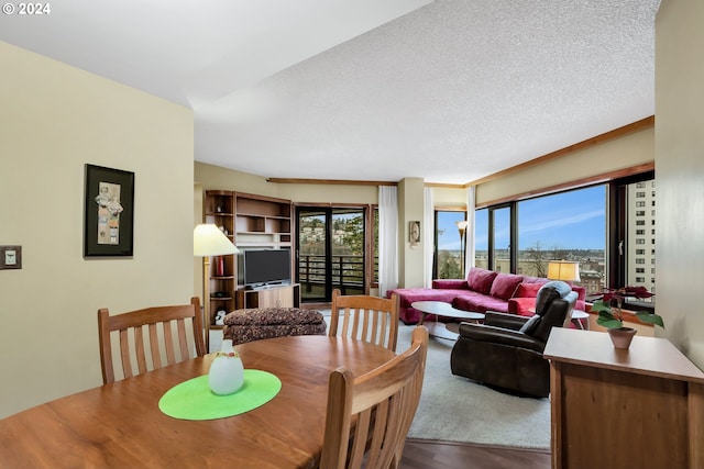 dining space with hardwood / wood-style floors and a textured ceiling