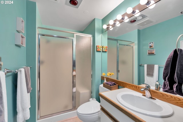 bathroom with tile patterned floors, vanity, toilet, and a shower with door