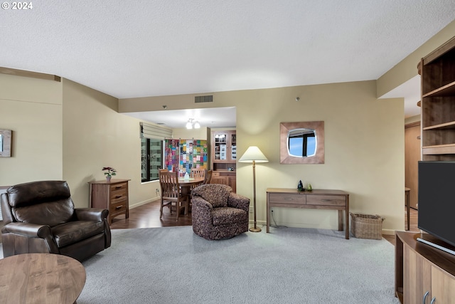 carpeted living room featuring a textured ceiling