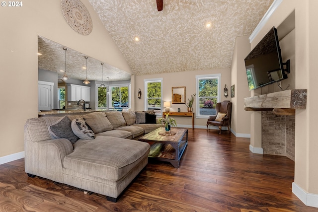 living room featuring a fireplace, sink, dark wood-type flooring, and high vaulted ceiling