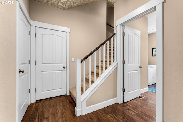 stairway with wood-type flooring and washer / clothes dryer