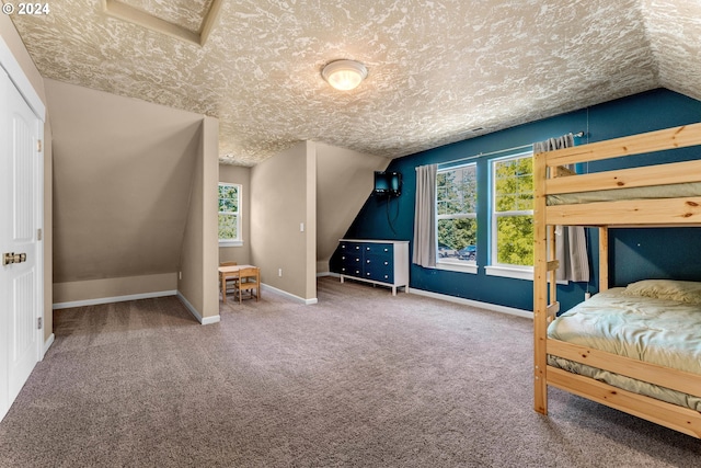 unfurnished bedroom featuring carpet, vaulted ceiling, and a textured ceiling