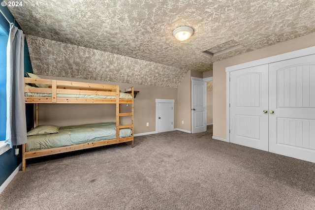 unfurnished bedroom featuring carpet flooring, vaulted ceiling, and a closet