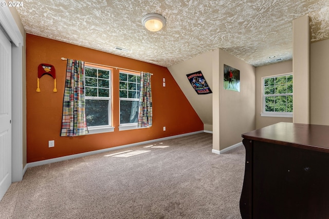 interior space with a textured ceiling, a closet, and multiple windows