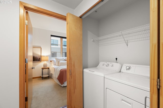 clothes washing area with washing machine and clothes dryer and carpet floors