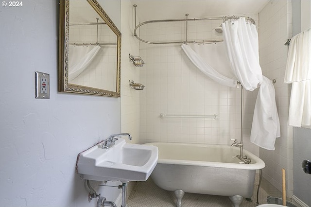 bathroom with a sink and shower / tub combo with curtain