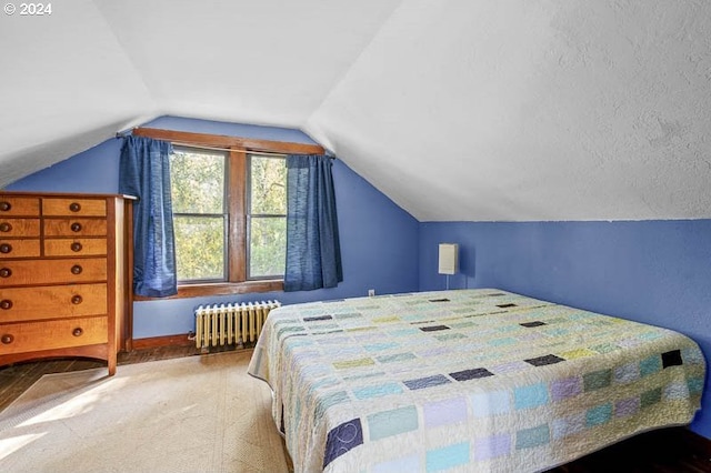 bedroom featuring radiator, lofted ceiling, and baseboards
