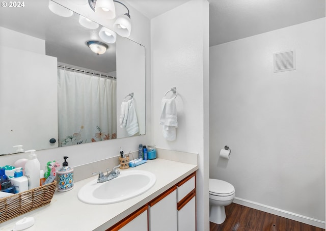 bathroom featuring vanity, toilet, and hardwood / wood-style flooring