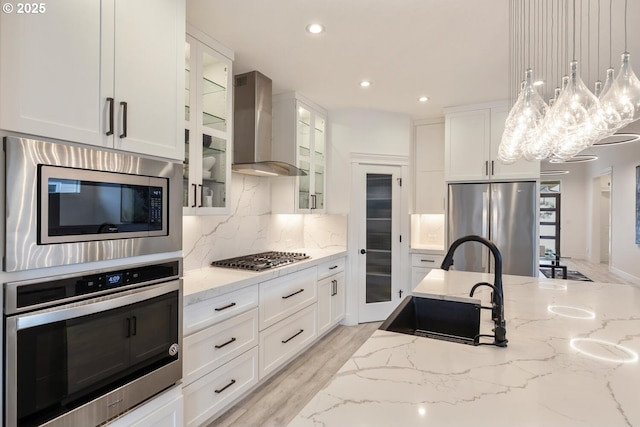 4116 S 16th Way, Ridgefield, WA 98642 - kitchen with appliances with stainless steel finishes, a sink, wall chimney range hood, backsplash, and light stone counters