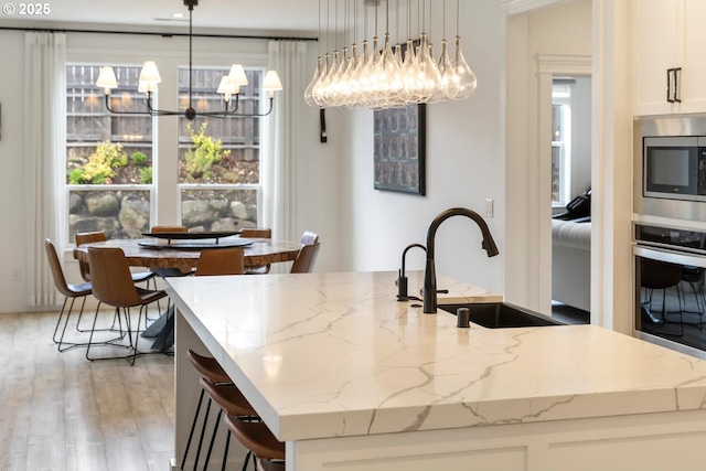 4116 S 16th Way, Ridgefield, WA 98642 - kitchen with a chandelier, stainless steel appliances, a sink, a kitchen island with sink, and light wood-style floors