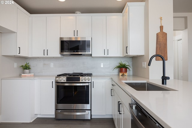20536 Empire Ave, Bend, OR 97701 - kitchen featuring appliances with stainless steel finishes, a sink, light countertops, tasteful backsplash, and white cabinetry