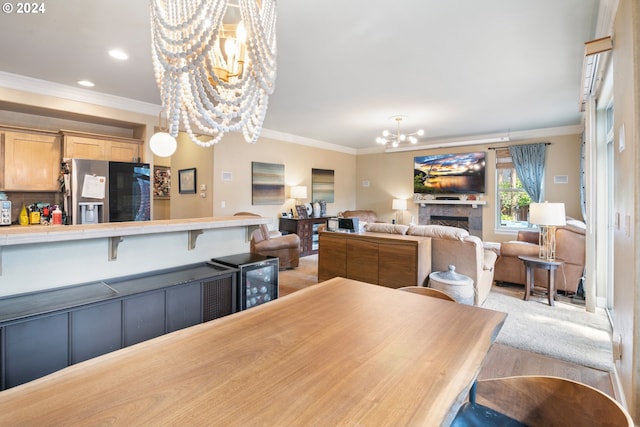 dining space featuring light hardwood / wood-style floors, ornamental molding, and a chandelier