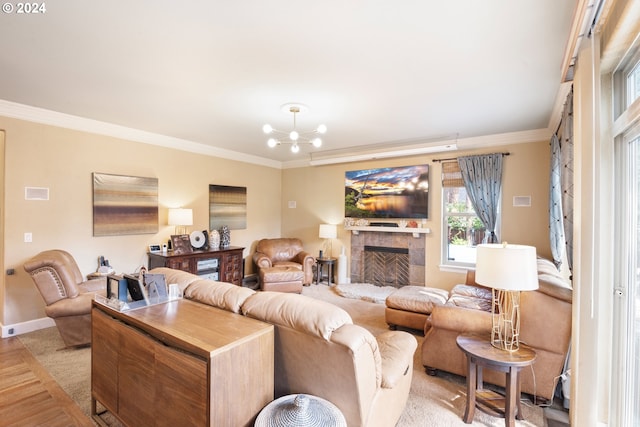 living room featuring a tiled fireplace, crown molding, light hardwood / wood-style flooring, and a chandelier