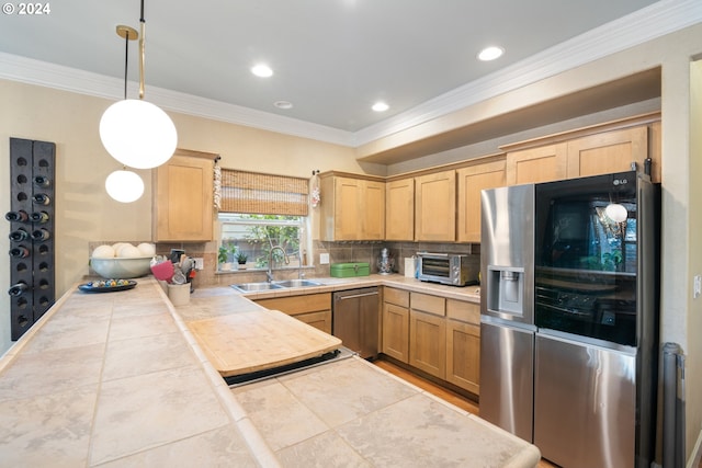 kitchen featuring tasteful backsplash, appliances with stainless steel finishes, tile countertops, sink, and decorative light fixtures