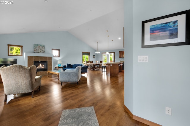 living room with high vaulted ceiling, hardwood / wood-style floors, and a fireplace